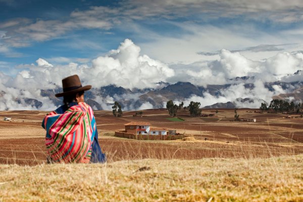 Peru, Chinchero, Indian woman and mountains.
