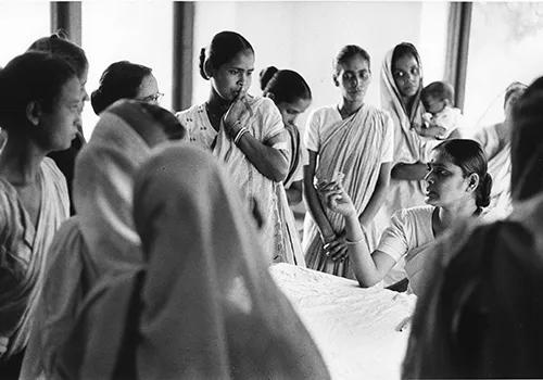 A black and white photo of Indian women speaking together. The foundation opened its first international non-US office in India in 1952.