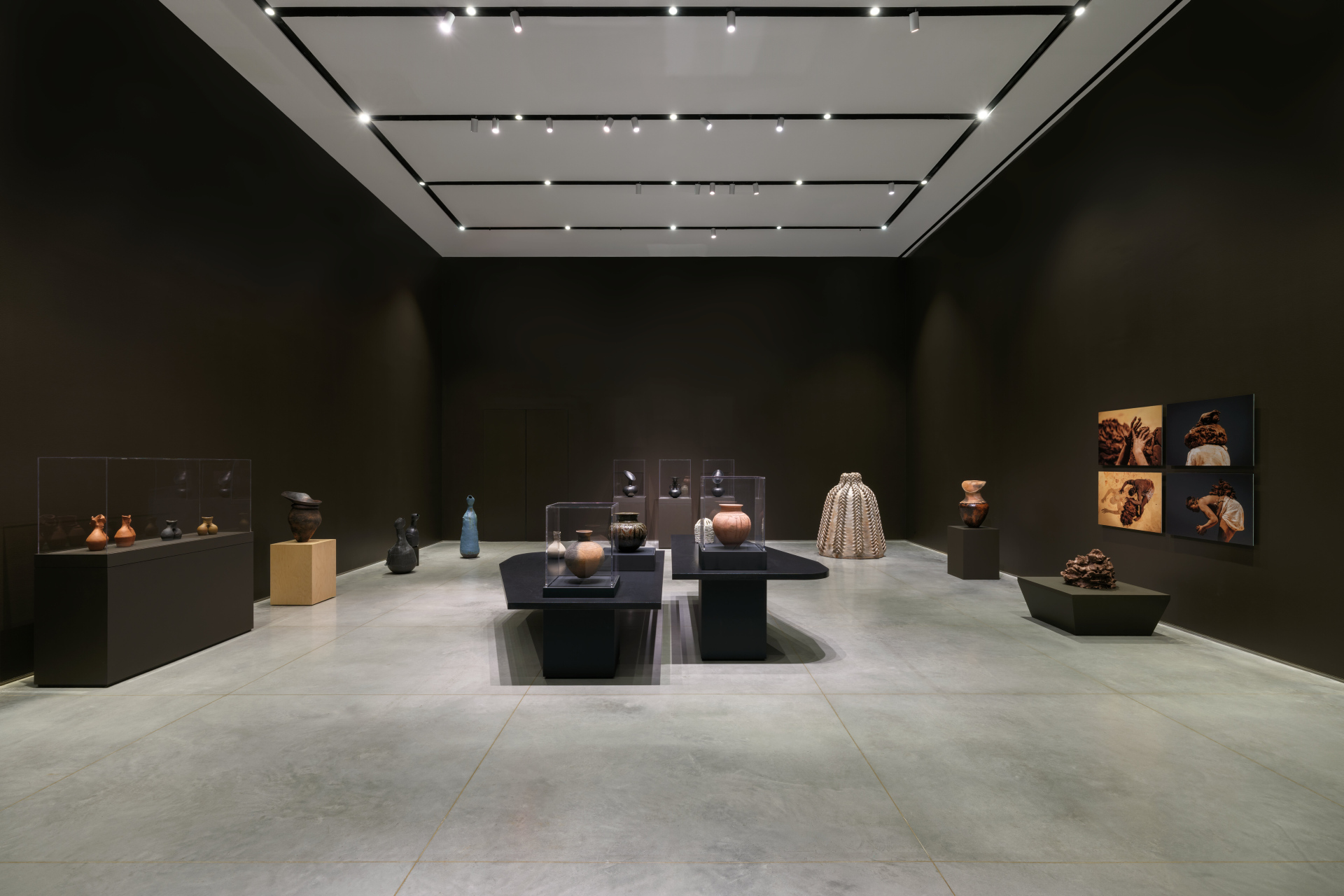 A wide-shot installation view of a gallery exhibition that features artworks relating to clay.